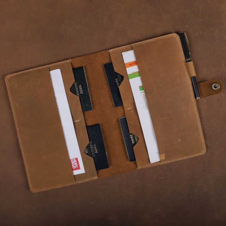 Brown leather wallet with cards and a pen on a brown background