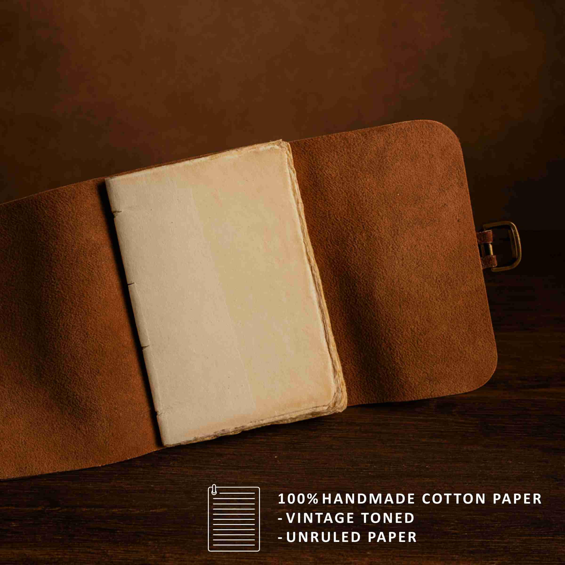 Brown leather-bound notebook with open pages on a dark background, featuring text about handmade cotton paper.