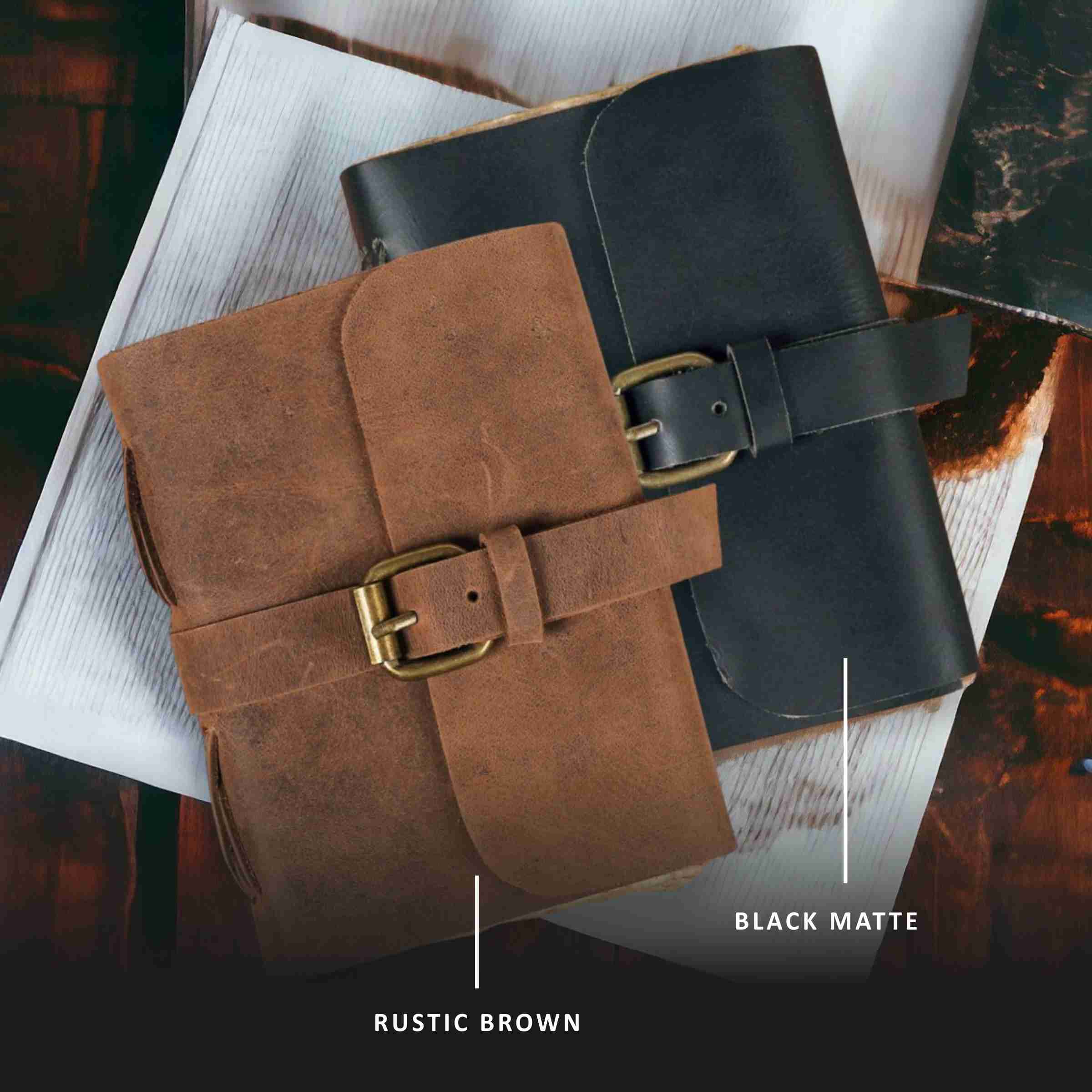 Two leather-bound books, one black and one rustic brown, on a textured surface.