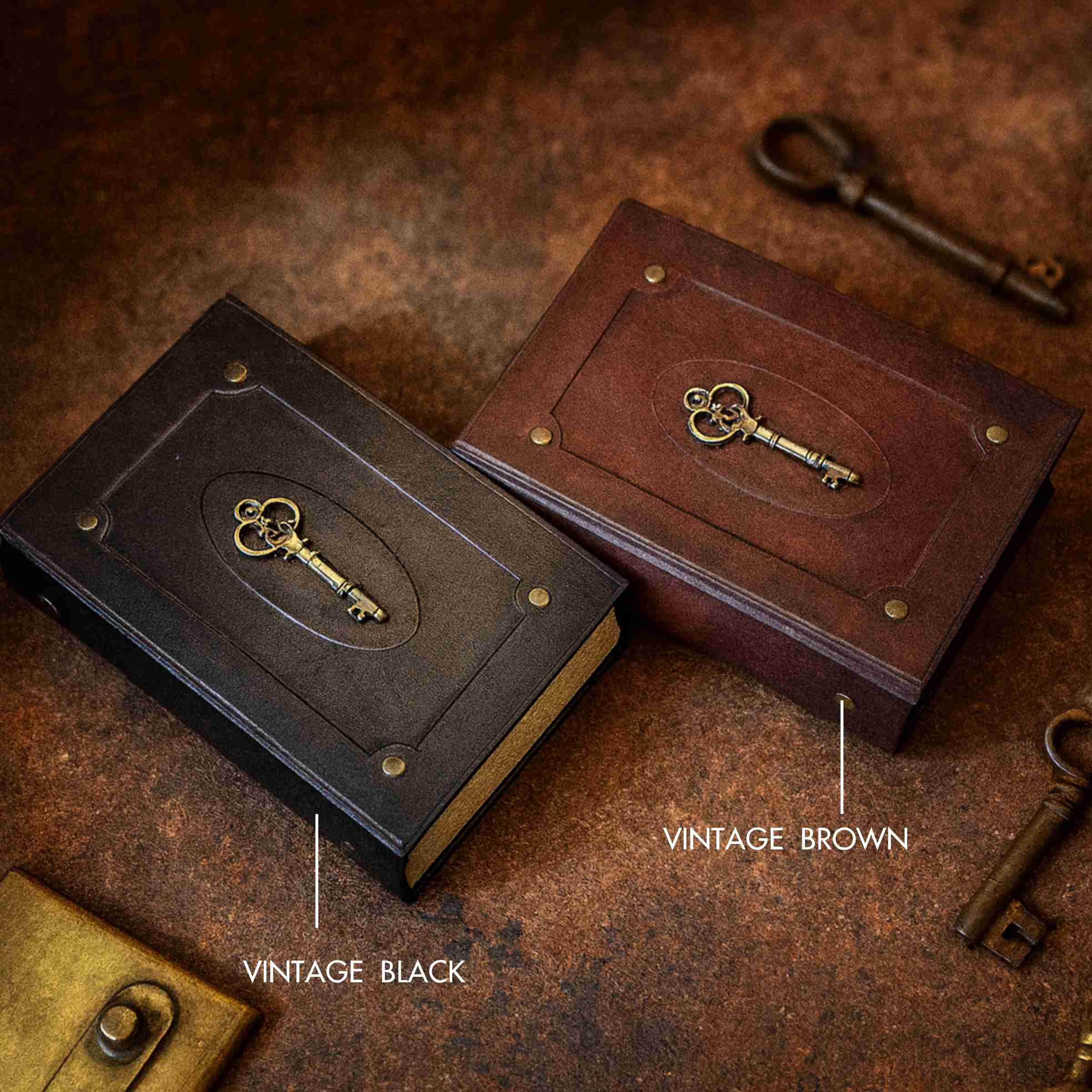 Two leather-bound books with key designs on a rustic surface, labeled 'Vintage Black' and 'Vintage Brown'.