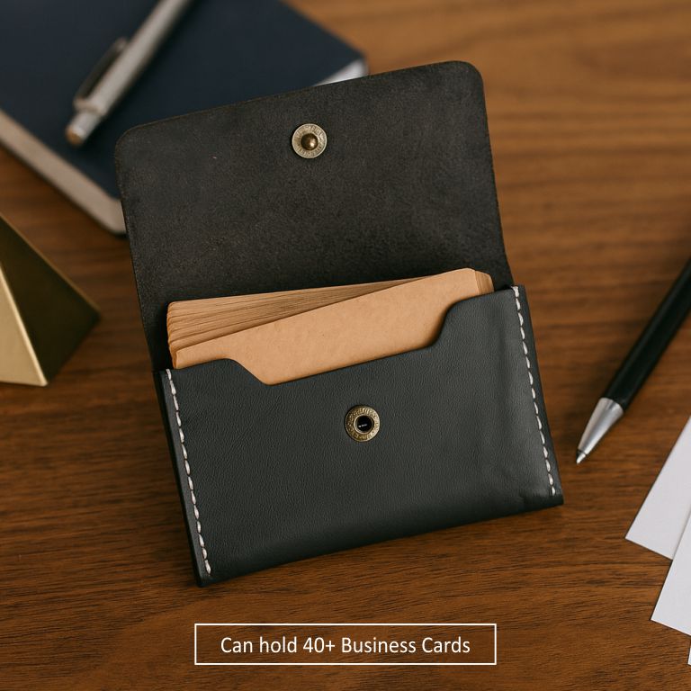 Black leather cardholder with brown interior on a wooden surface