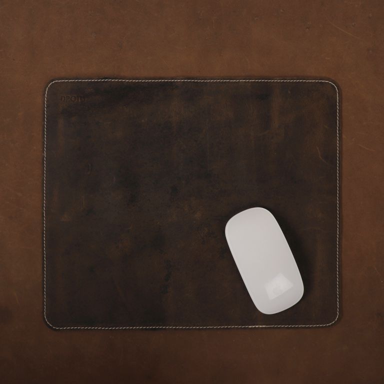 Brown leather mouse pad with a white mouse on a brown surface