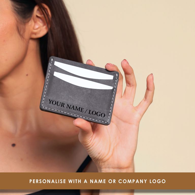 Person holding a gray cardholder with customizable text on a beige background