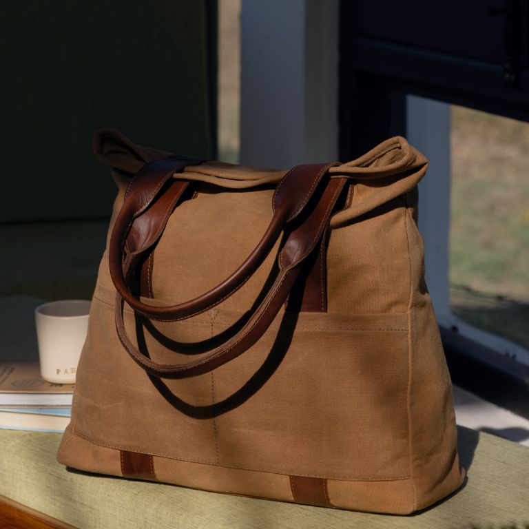 Brown leather handbag with brown straps on a surface