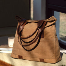 Load image into Gallery viewer, Brown tote bag with leather handles, highlighting its simple and elegant design