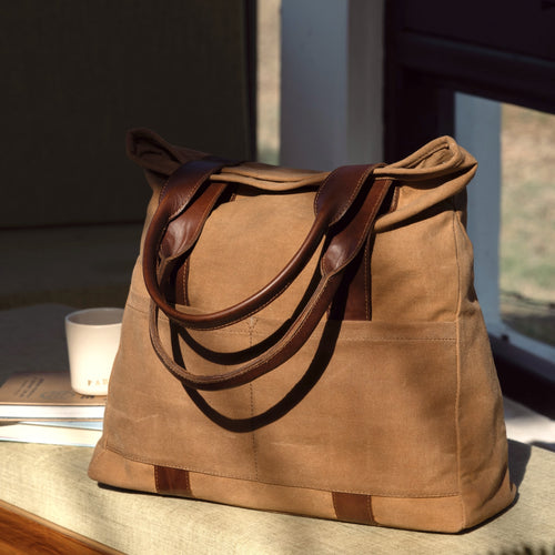 Brown tote bag with leather handles, highlighting its simple and elegant design